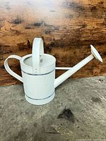 Left-side view of watering can showing handle, lid and spout