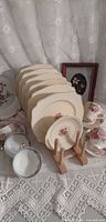 Stack of six luncheon plates in rack plus matching saucer in front
