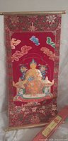 Full view of red fabric banner with Buddha image