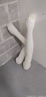 Both mannequin arms leaning against wall