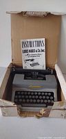 Typewriter inside original box with instruction booklet upright