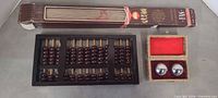 Group shot showing abacus, boxed fan, Baoding balls in open case