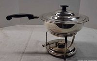 Side view showing pan on stand with burner cup and handle
