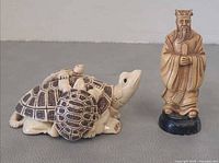 Turtle and scholar figurines side by side showing scale and form