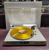 Front view of Dual CS 630 Q turntable playing a record with lid open