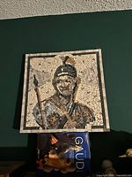 Front view of square marble mosaic artwork showing Roman soldier image