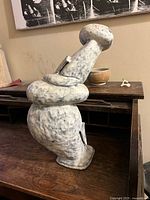 Side view of entire ceramic surrealist sculpture on desk