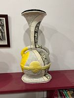 Front view of ceramic surrealist vase showing full form and painted design