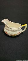 Right side of Grantham floral creamer showing yellow handle, dotted rim, floral band