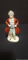 Front view of porcelain gentleman figurine showing attire and base