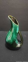 Left side profile of deep green glazed ceramic pitcher with loop handle