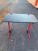 Top view of gaming desk showing black surface and cable grommets