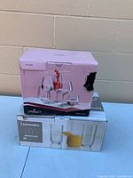 Two boxed glassware sets stacked: Luminarc Nitro 18-piece tumblers and Crystalex 6-piece wine glasses, showing damaged outer box