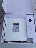 Gateway device seated in box showing front display window and touch keys