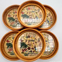 Top view of five stacked coasters to show rattan rims and Florida map inserts