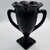Front of vase showing ruffled rim, handles, pedestal base