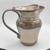 Side profile of stoneware jug showing handle, spout, glazing and blue band