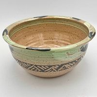 Oblique view of bowl showing exterior carved band, glaze and overall form