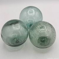 Three pale aqua glass spheres grouped together