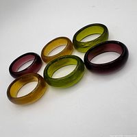 Six glass napkin rings arranged flat showing colour variety