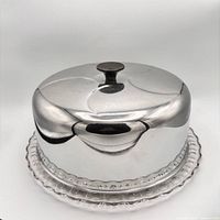Metal cake dome on pressed glass plate, front view