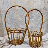 Front view of both bamboo rattan planter baskets, showing size difference and handles