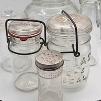 Front view of assorted six clear glass jars and bottle