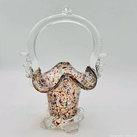 Front view of art glass basket showing confetti body, clear handle and base