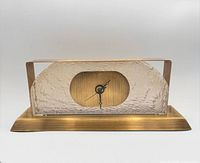 Front view of lucite and brass-tone desk clock showing dial