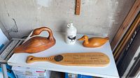 Group view of both wooden duck decoys, cribbage board, and ceramic jug