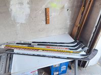 Six hockey sticks stacked on table