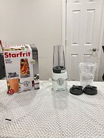 Boxed Starfrit blender, assembled base with cup, two lids and extra cup