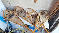 Four wooden snowshoes laid out showing overall condition
