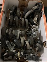 Top-down view of box full of assorted heavy duty caster wheels