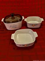 Three CorningWare casserole dishes showing sizes, patterns, and lid