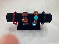 Four bracelets displayed on black velvet stand