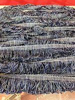 Full length of blue-grey looped fringe trim coiled