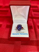 Ring in presentation box showing tanzanite stone and interior label