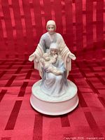 Front view of Arnart porcelain Holy Family music box on round base