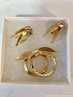 Brooch and two clip-on earrings displayed in box