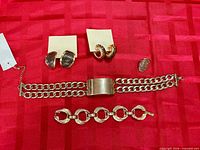 All five jewelry pieces displayed on red fabric