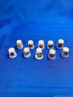 Full set of ten porcelain thimbles on blue background