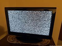 Front view of 32-inch Toshiba TV powered on displaying static