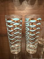 Two clear highball glasses with blue and gold wave pattern
