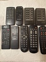 Ten assorted remotes laid out on surface