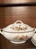 covered serving bowl with lid showing pine motif and handles