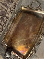 rectangular silver-plated tray close-up showing ornate border and surface