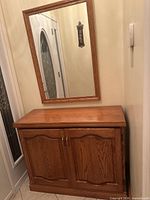 Cabinet with matching mirror mounted above, full view