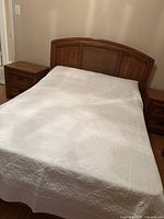 Full view of double bed with rattan headboard and both nightstands