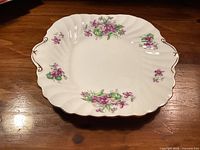 Top view showing floral pattern, scalloped edge, gold trim